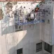 Trabajadores realizando rehabilitación y pintura en patio interior de edificio en Sevilla, con sistemas de seguridad vertical