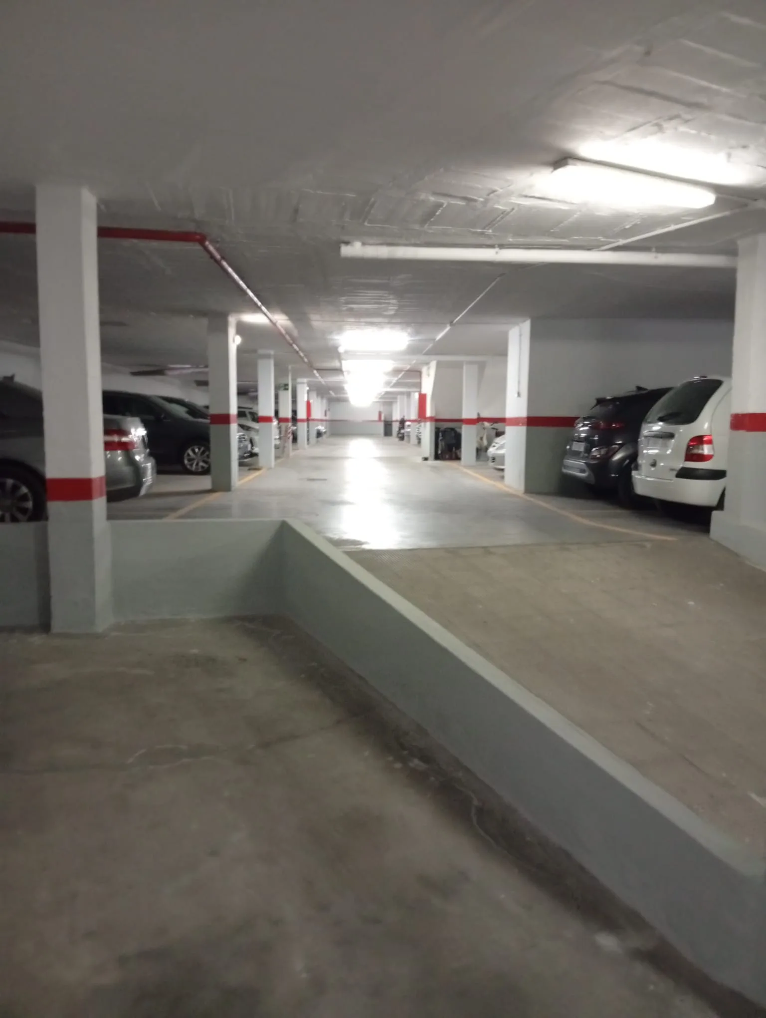 Parking de comunidad en Sevilla con pintura renovada y señalización horizontal recién aplicada.
